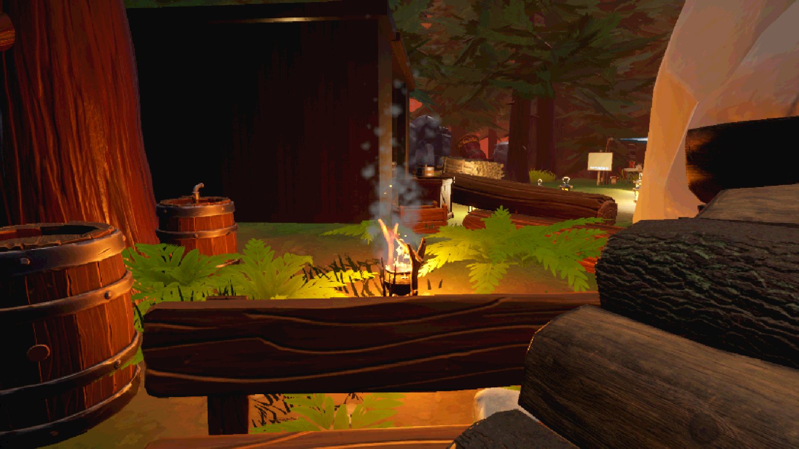 View across the camp at night with barrels and a fire